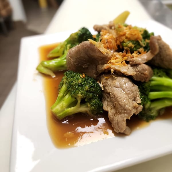 Thai House Bistro's beef and broccoli dish, garnished with crispy fried garlic, in a savory brown sauce.