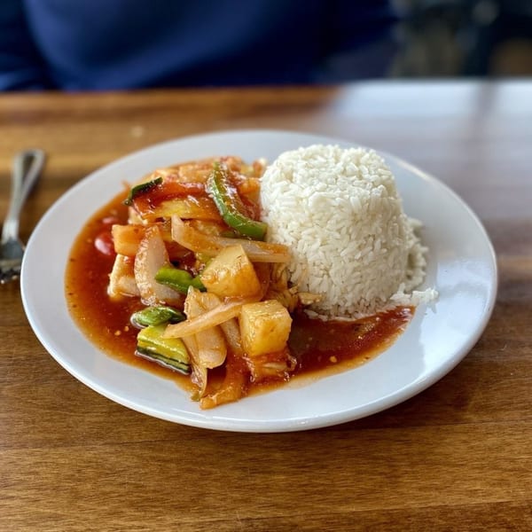 Sweet and sour chicken with pineapple, onions, and green peppers, served with white rice.