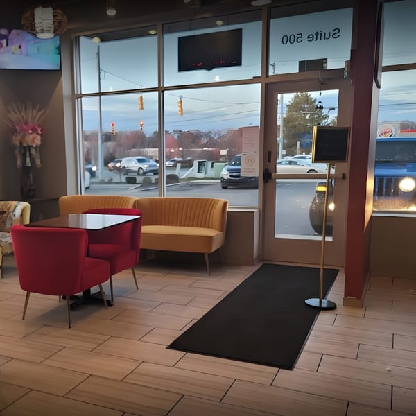 Interior of Thai House Bistro with red chairs, yellow benches, and large windows looking out to a street.